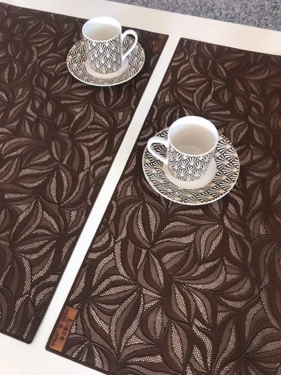 Brązowe podkładki Zen 30 × 45 cm w liście na stole z filiżankami