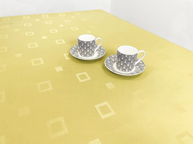 Żółty obrus plamoodporny 120 × 120 cm w subtelne kwadraty – aranżacja na stole