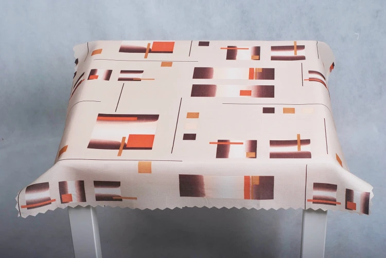 Obrus plamoodporny 75 × 75 cm w brązowo-pomarańczowe figury geometryczne – drugi widok obrusu na stole