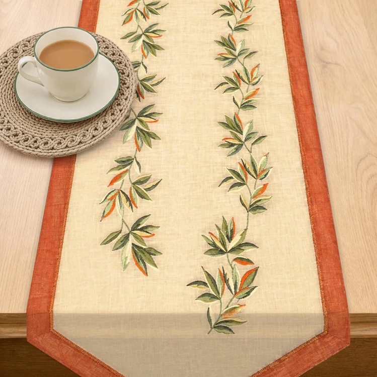 Bieżnik Salsa 40 × 140 cm pomarańczowo-zielone liście, białe tło – widok w aranżacji na stole