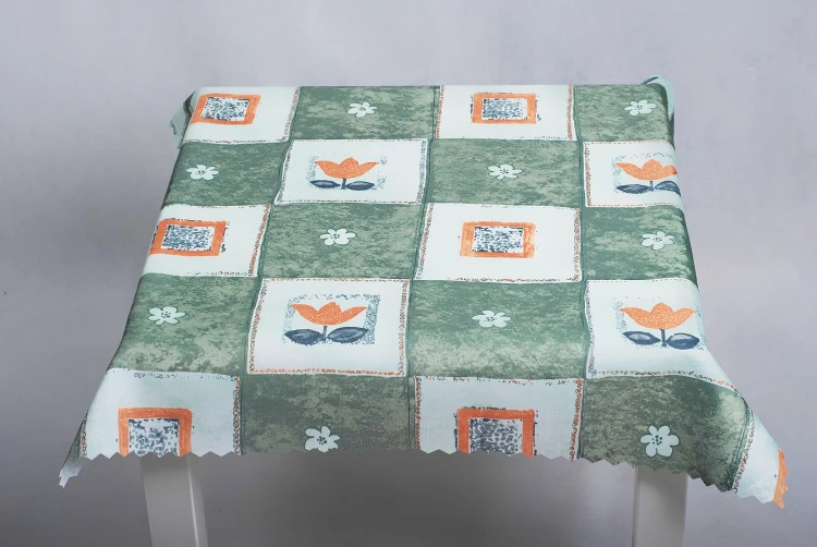Obrus plamoodporny 75 × 75 cm w zieloną kratę i pomarańczowe tulipany – widok obrusu od przodu na stole
